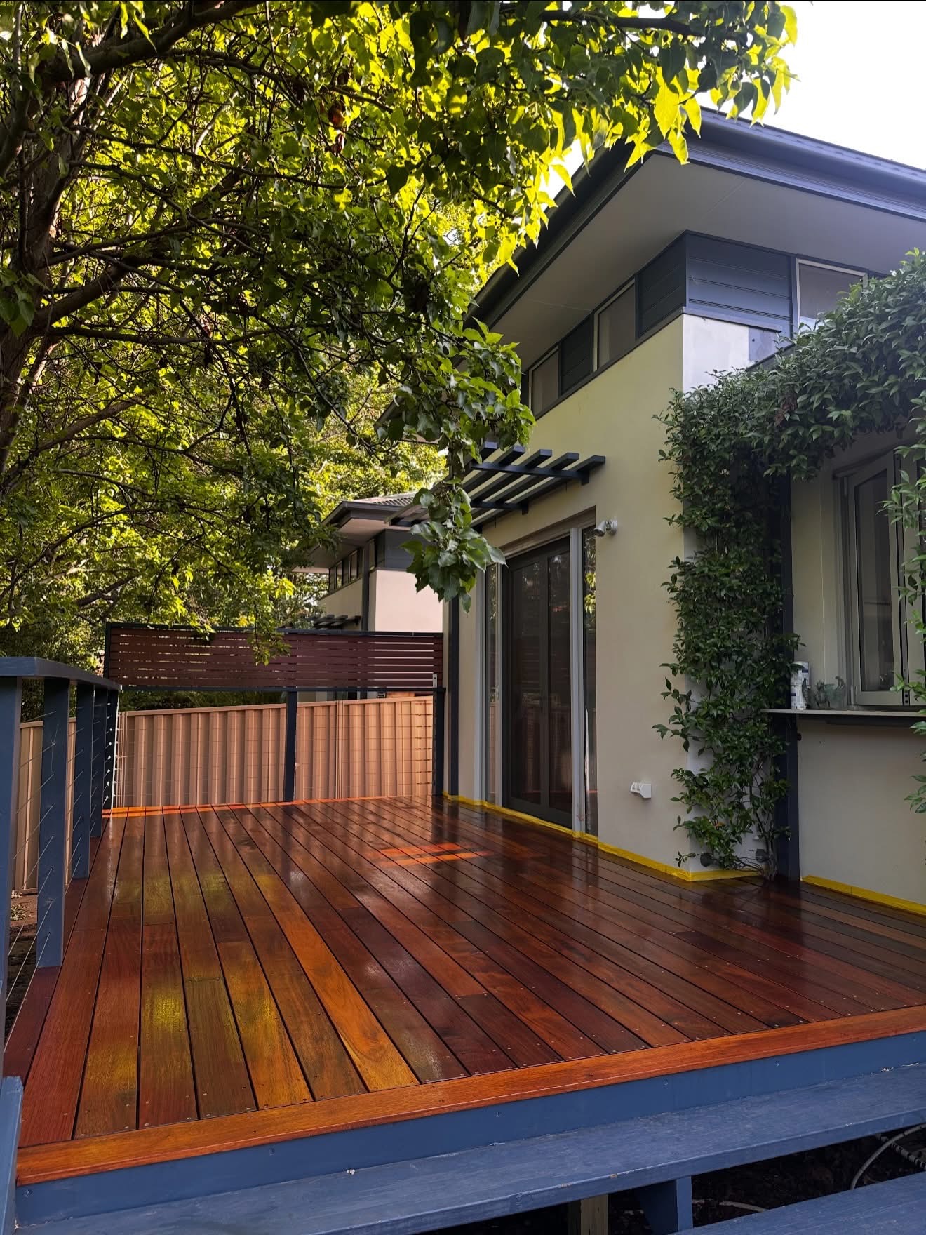 Raised timber deck and steps beside a two-storey home