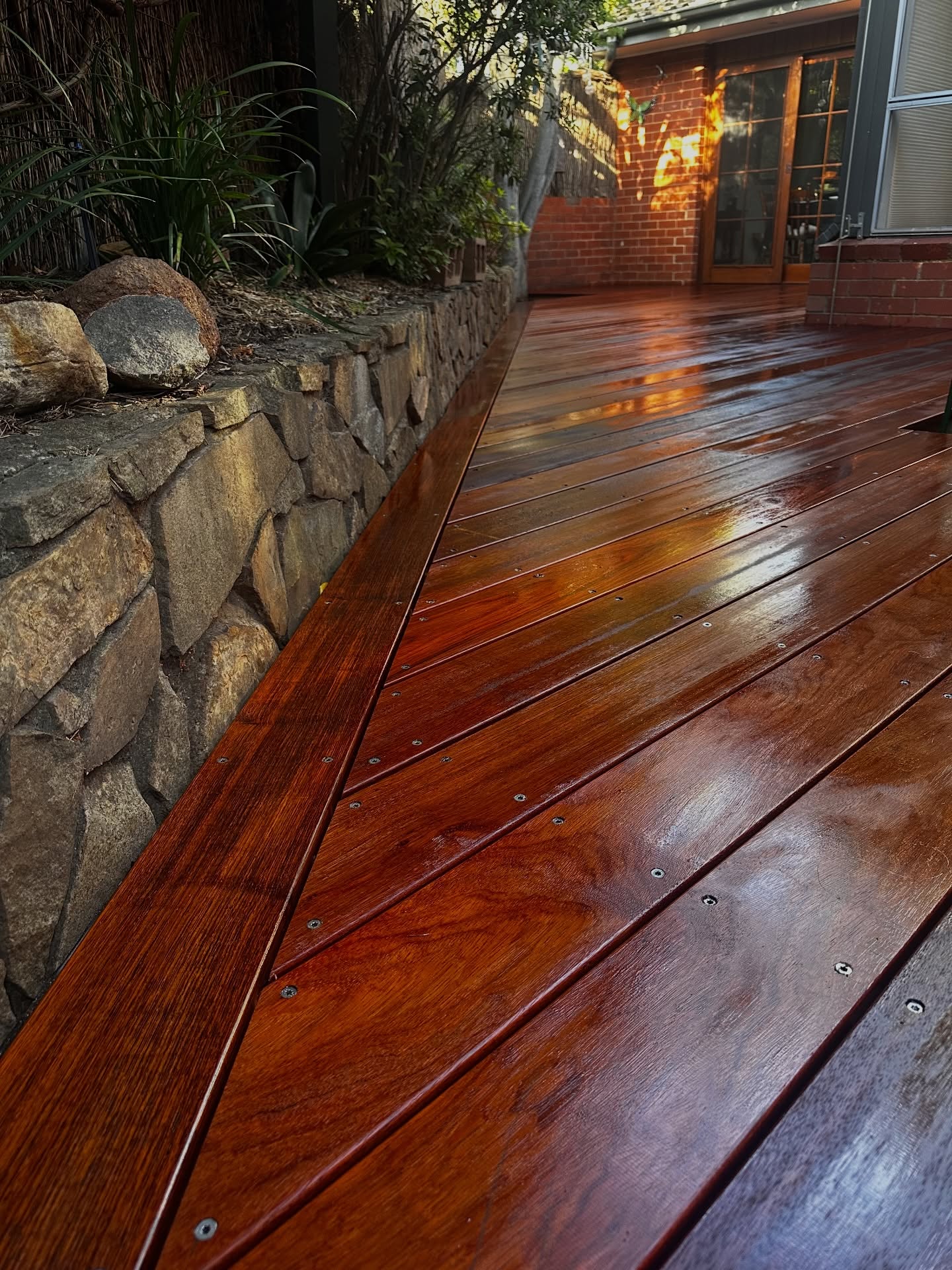 Finished timber deck beside a garden wall